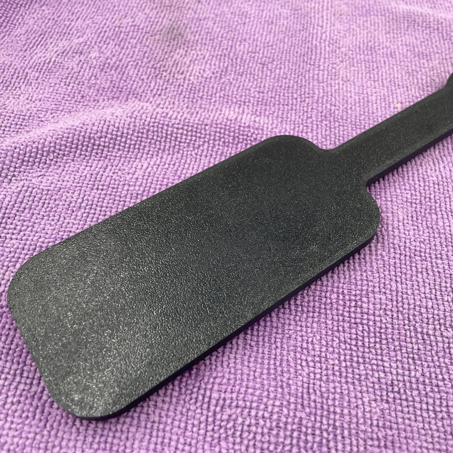 De achterkant van een kleine zwarte BDSM paddle