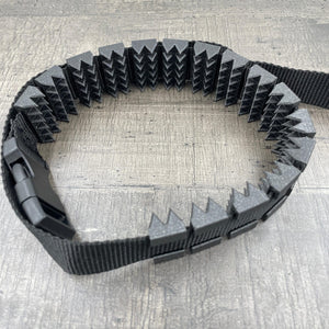 Een BDSM cilice met een zwarte band en spikes in de kleur zwart met glitters