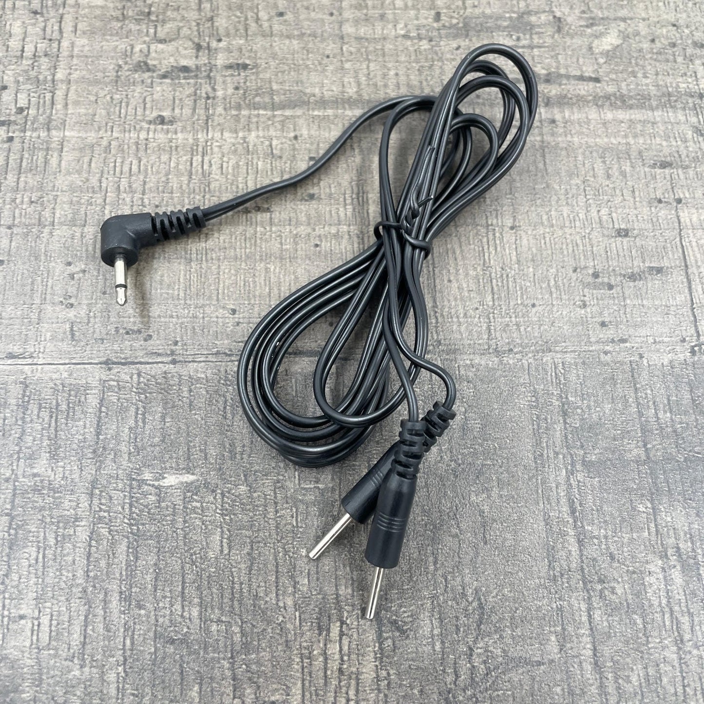 Een zwarte kabel voor e-stim producten met een Rimba plug en twee 2mm pluggen