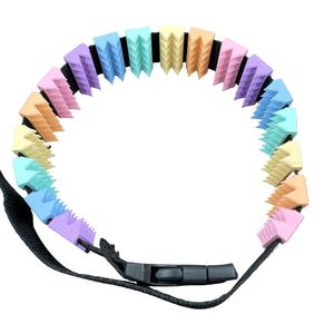 Een BDSM cilice met een zwarte band en spikes in pastelkleuren