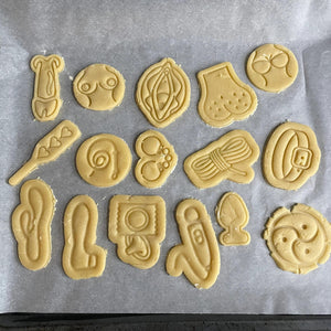 Koekjes in de vorm van verschillende seksspeeltjes en intieme lichaamsdelen.