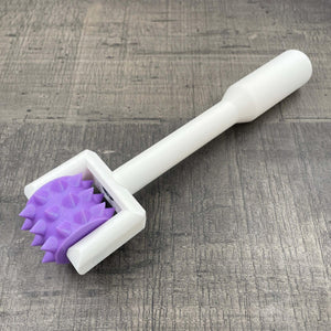 Een BDSM pinwheel met een wit handvat en een paars wieltje