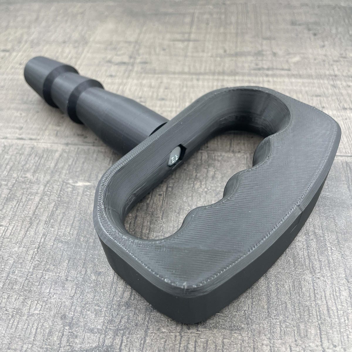 Een adapter voor vac-u-lock seks toys met een zwarte handgreep.