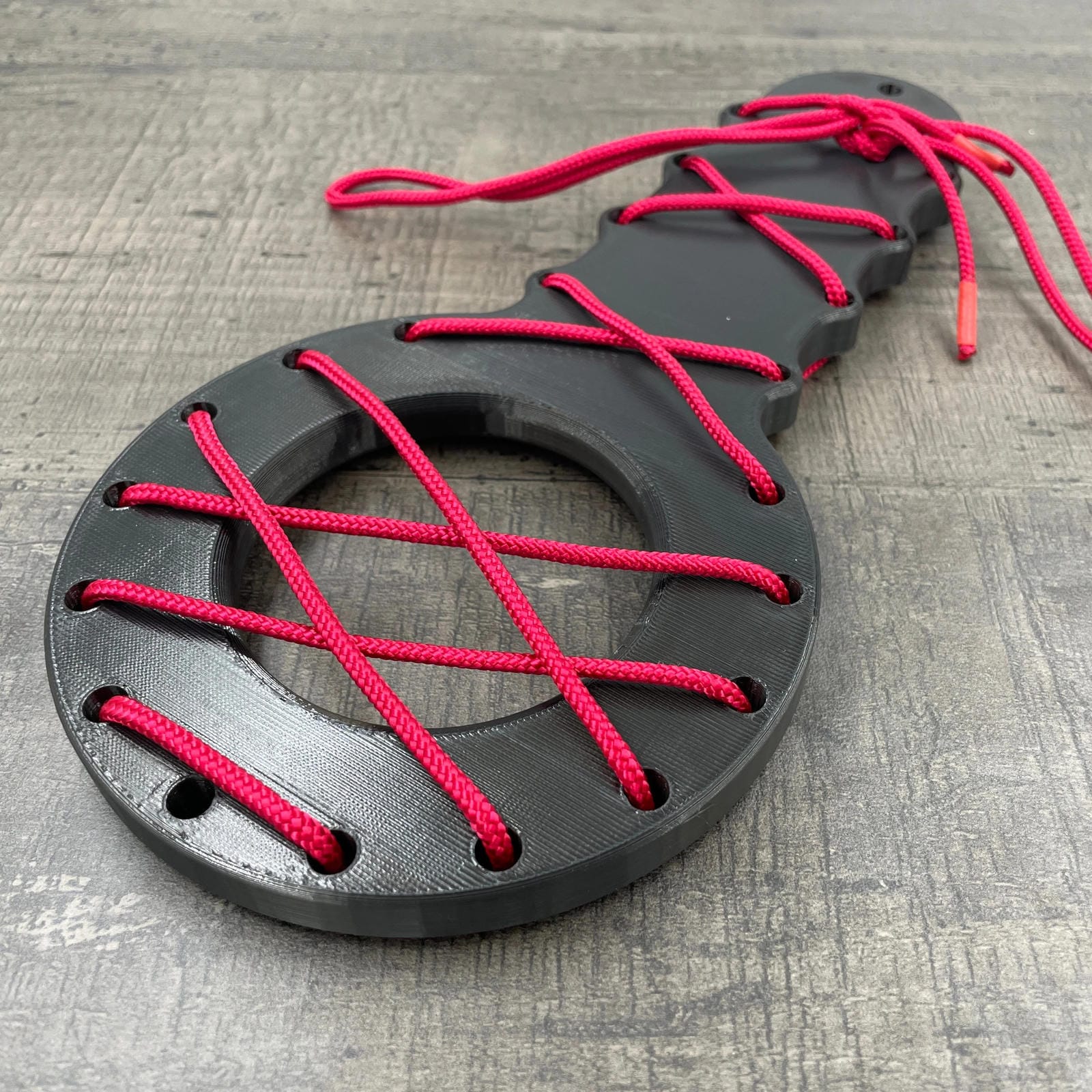 Een BDSM CBT plankje met rood touw