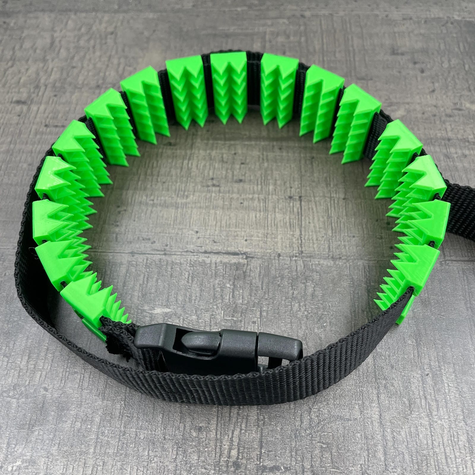 Een BDSM cilice met een zwarte band en spikes in de kleur groen