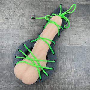 Een BDSM CBT plankje met groen touw en een dildo