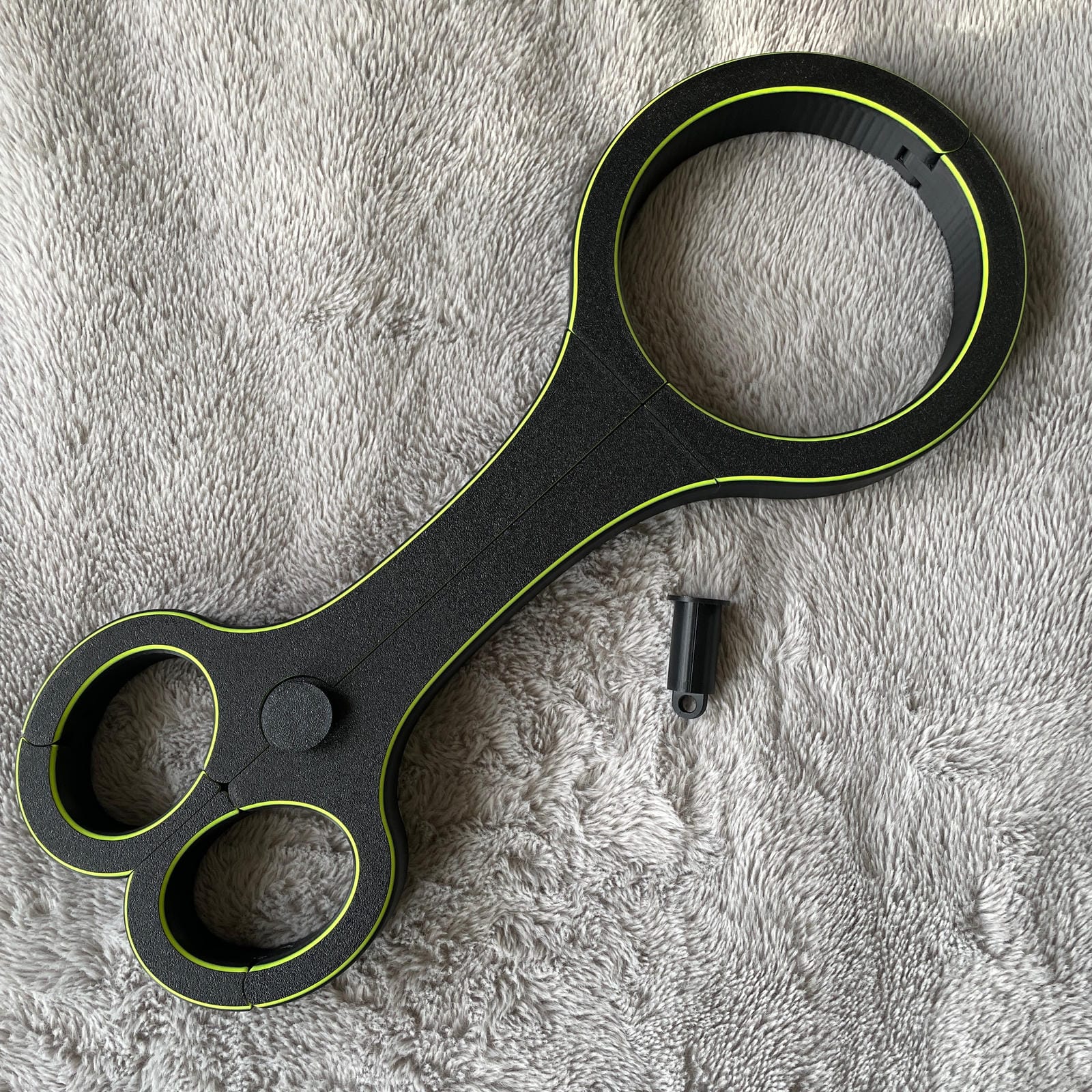 Een BDSM rigid fiddle in het zwart met UV-gele accenten