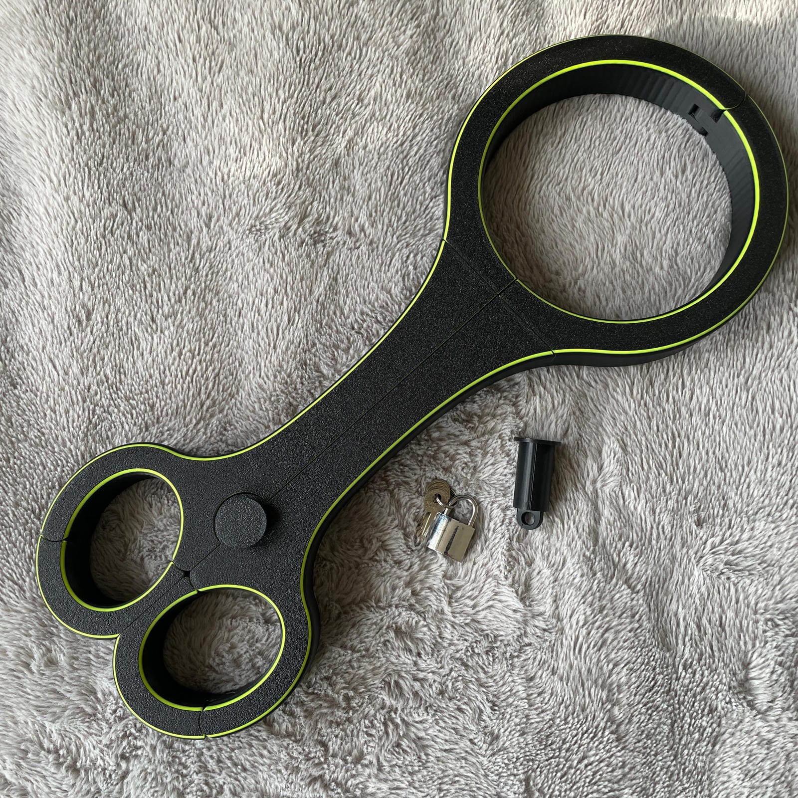 Een BDSM rigid fiddle in het zwart met UV-gele accenten