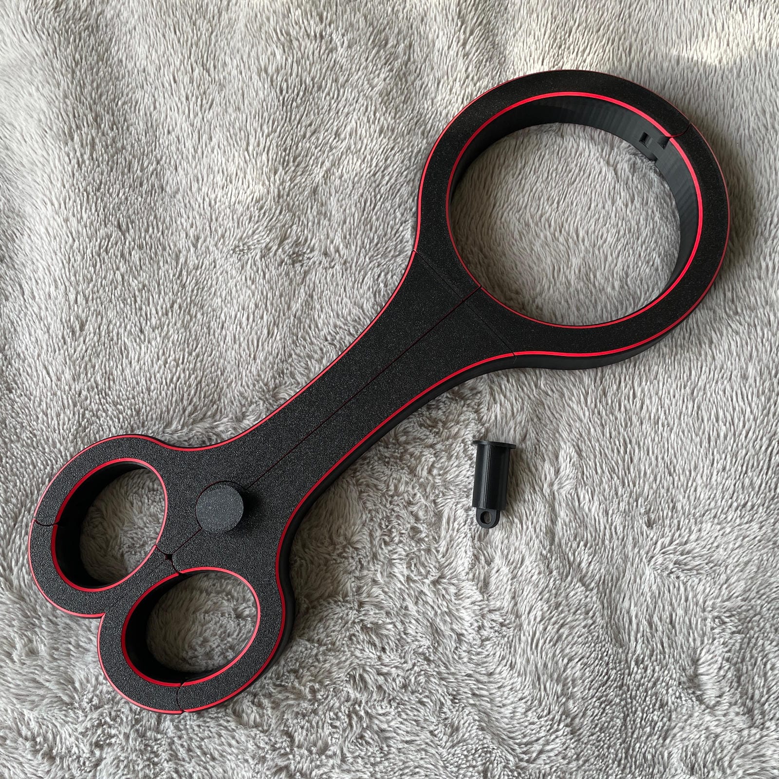 Een BDSM rigid fiddle in het zwart met rode accenten