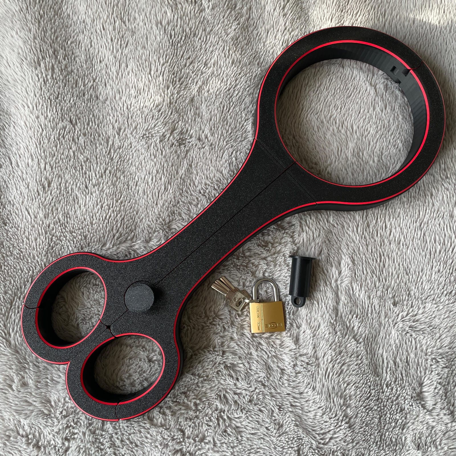 Een BDSM rigid fiddle in het zwart met rode accenten