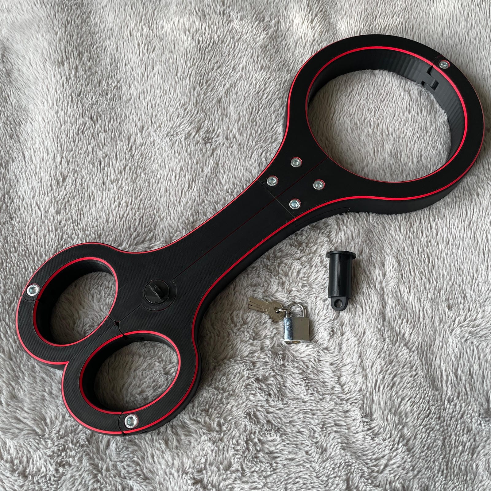 Een BDSM rigid fiddle in het zwart met rode accenten