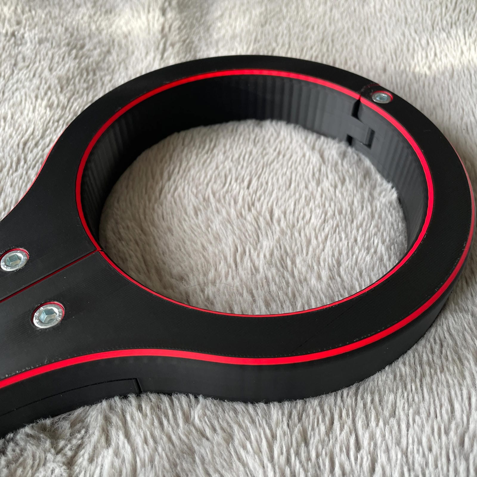 Detailfoto van de nek van een BDSM rigid fiddle in het zwart met rode accenten