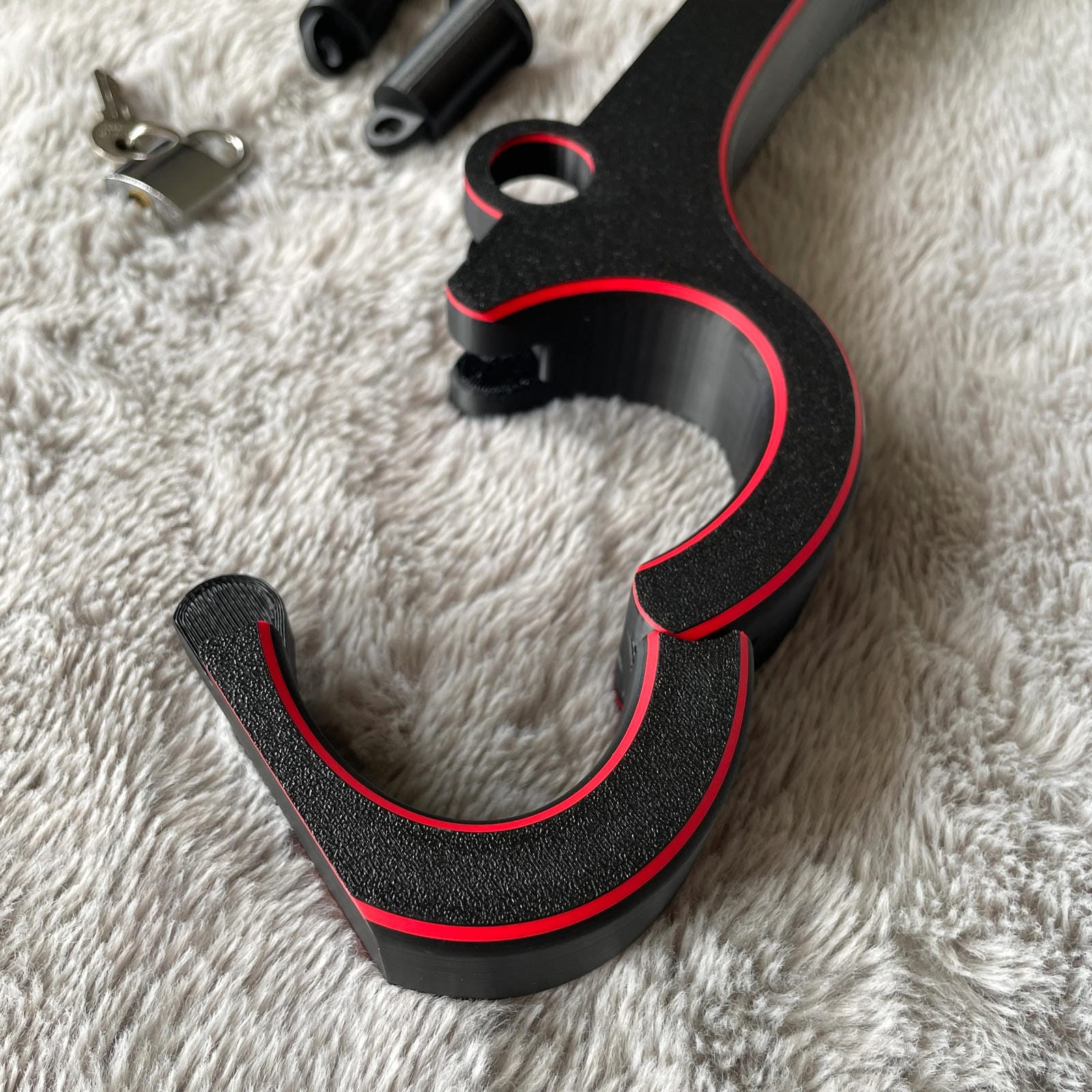 Detailfoto van de polsen van een BDSM rigid fiddle in het zwart met rode accenten