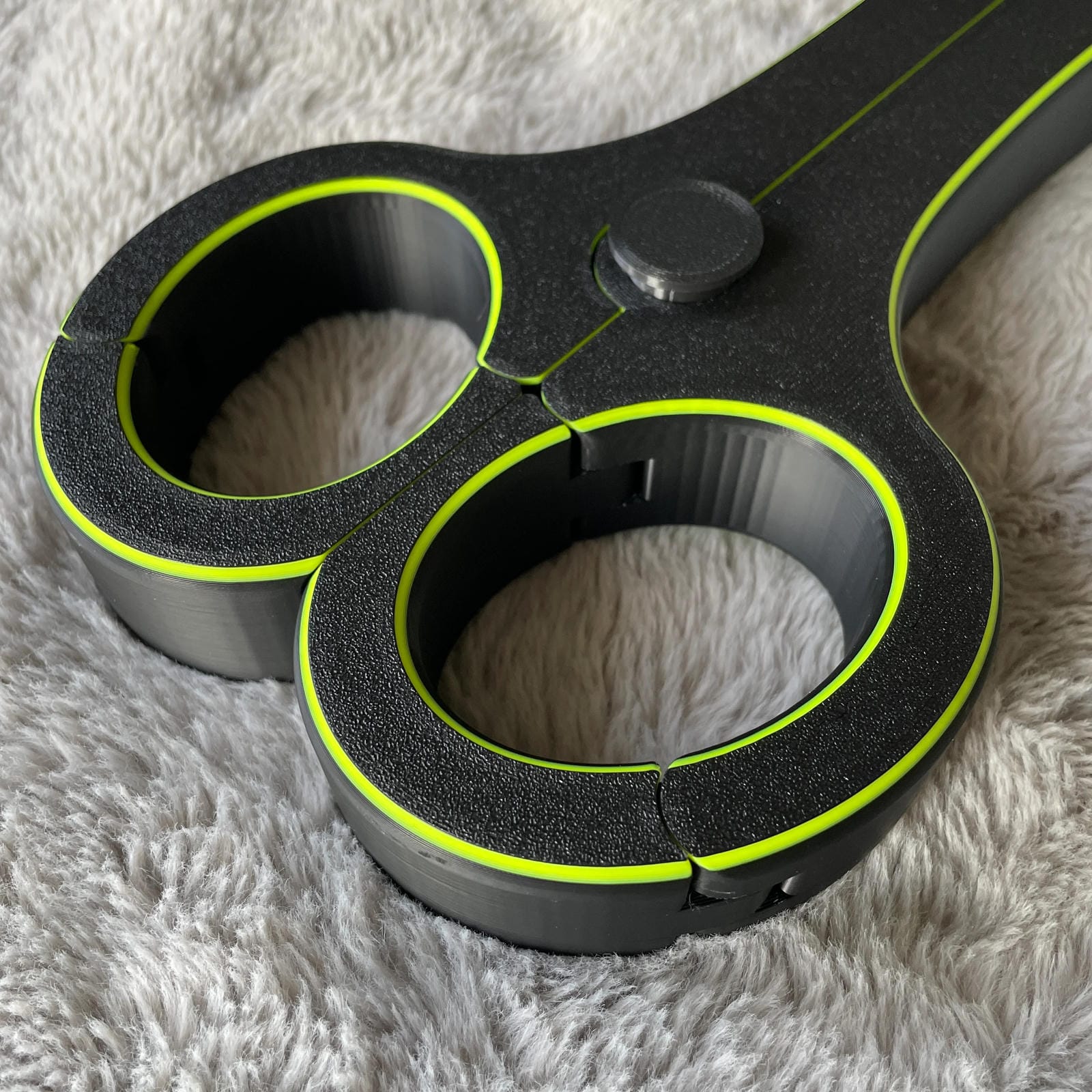 Detailfoto van de polsen van een BDSM rigid fiddle in het zwart met UV-gele accenten