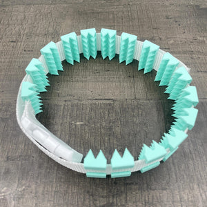 Een BDSM cilice met een witte band en mint-kleurige spikes