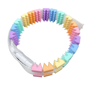 Een BDSM cilice met een witte band en spikes in regenboog kleuren