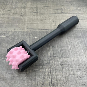 Een BDSM pinwheel met een zwart handvat en een roze wieltje