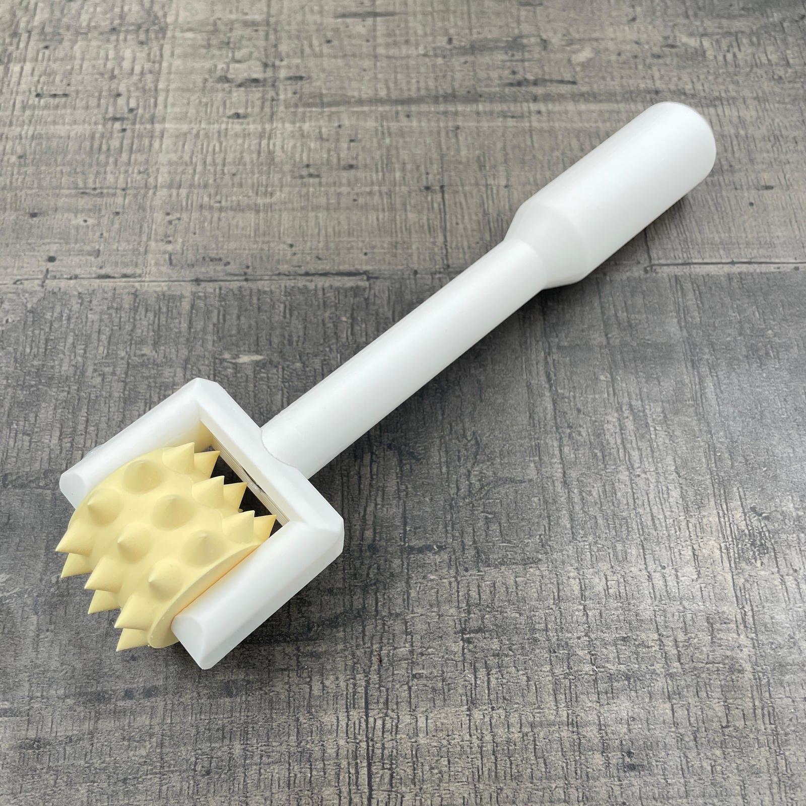 Een BDSM pinwheel met een wit handvat en een geel wieltje