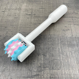 Een BDSM pinwheel met een wit handvat en wieltje in de kleuren van trans-vlag